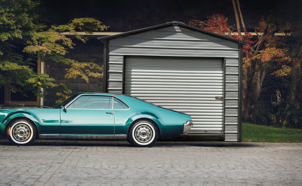 Classic car against an a frame style garage