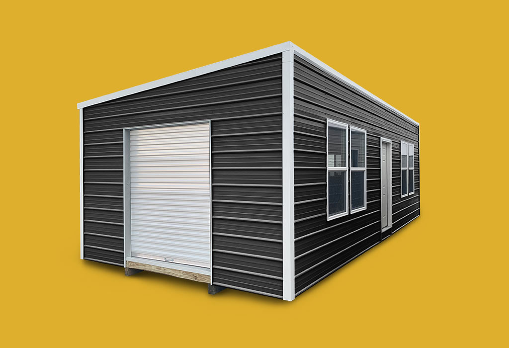 Black metal single slope style portable building with white trim against yellow background