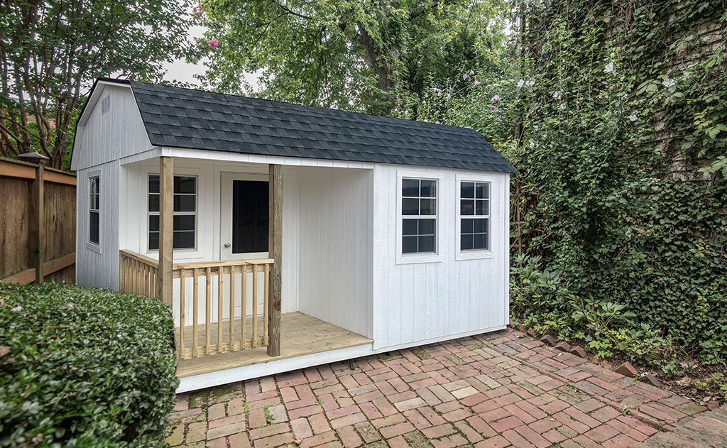 White tiny home with porch and black roof